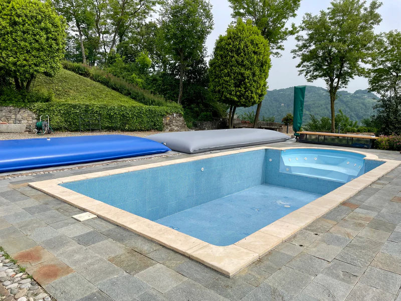 A reverse view of the same pool renovation site, showing temporary water storage tanks along the edge