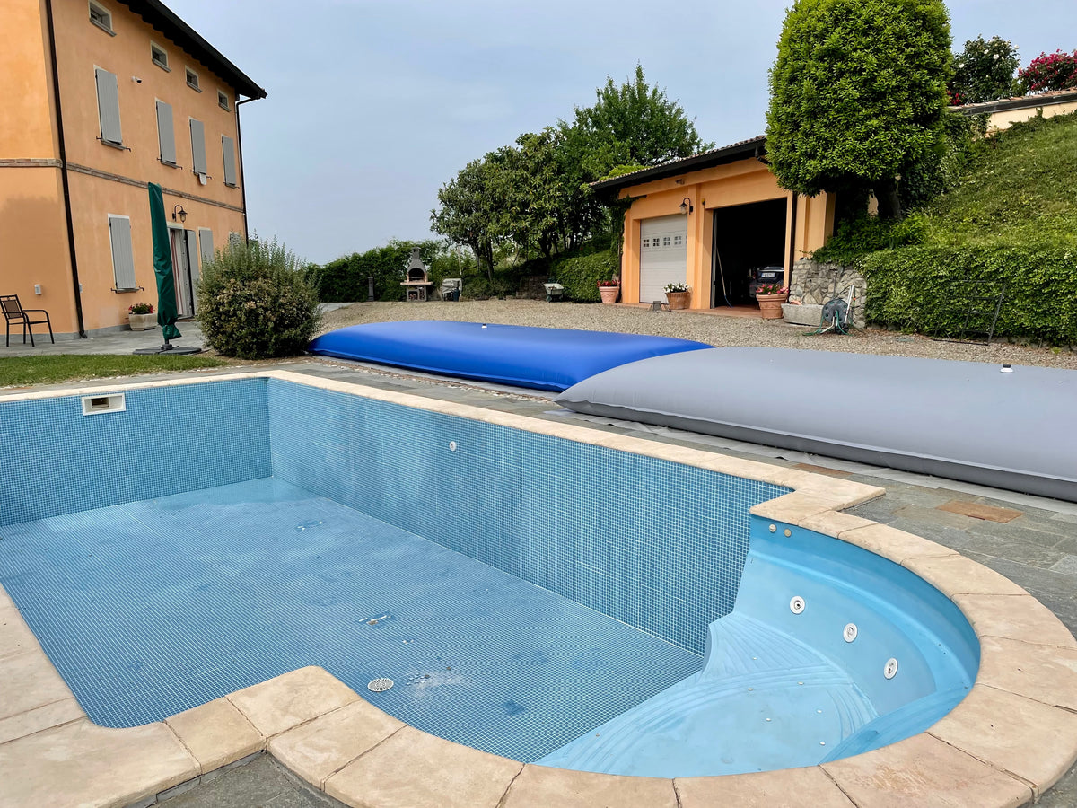 An empty pool ready for renovation, with the water held in blue and gray Fluid Flex tanks beside it